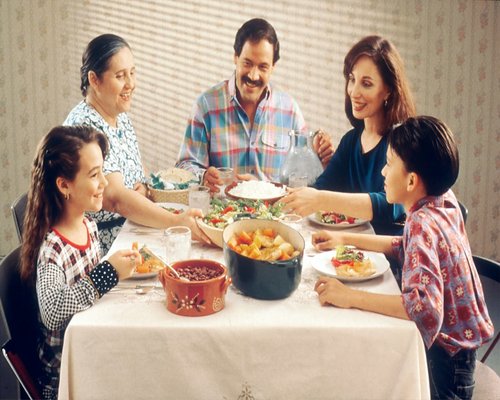 A family sharing a meal and resting at home without digital devices